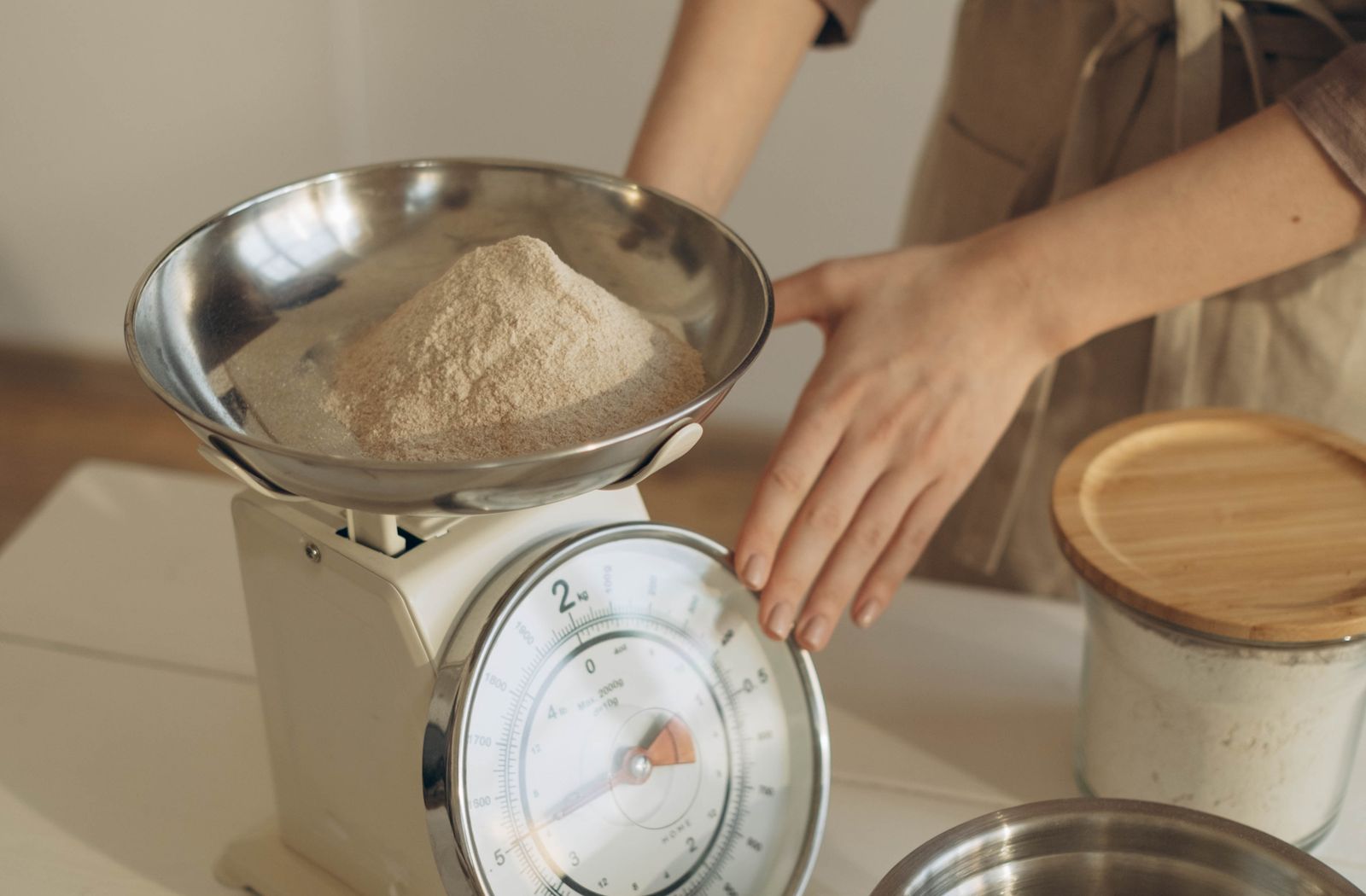 Mani che pesano la razione giornaliera su una bilancia da cucina